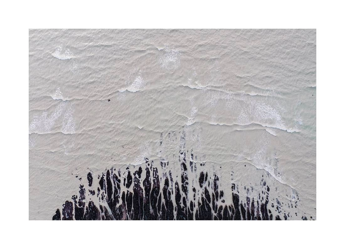 Normandie 04 - Luftaufnahme der zerklüfteten Küste der Normandie mit brechenden Wellen auf dunklem Felsstrand normandie i2v 0004 web - Normandie 04 - Luftaufnahme der zerklüfteten Küste der Normandie mit brechenden Wellen auf dunklem Felsstrand